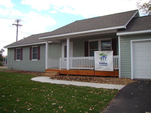 Ranch style house with porch; Twin Cities Habitat sign in front