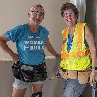 Two volunteers smiling on site at the Harrison townhomes.