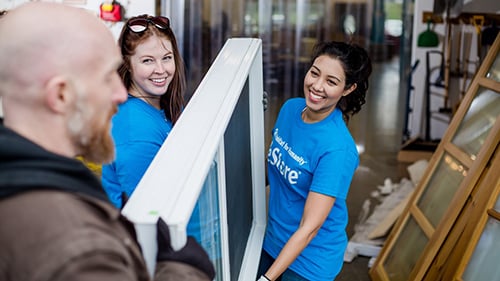 Smiling ReStore staff helping someone donate items.