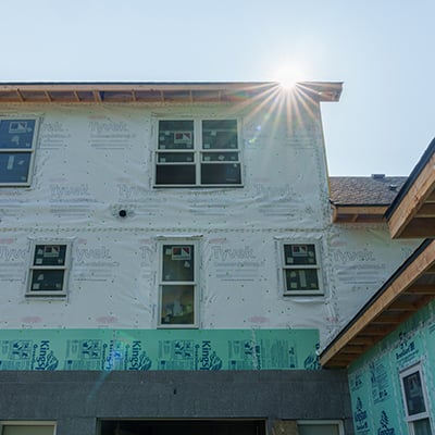 Exterior shot of townhome with sun shining over the roof.
