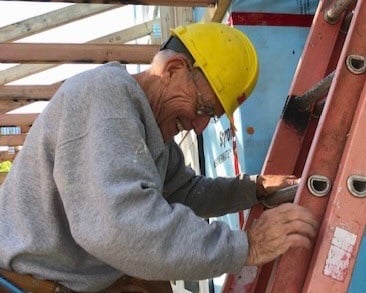 Bob smiling on a ladder.
