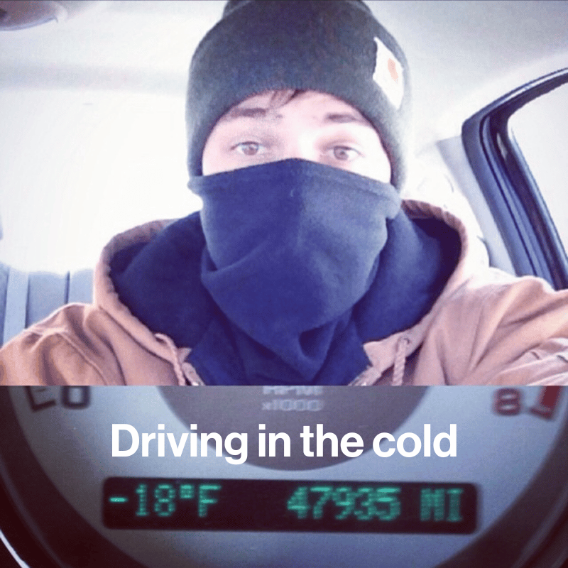 Greg driving in a car with a face mask on and cold temperature showing 
