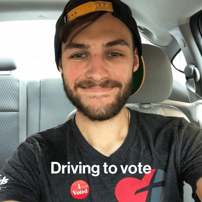 Greg sitting in his car with an I Voted sticker