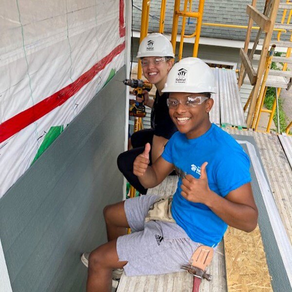 Two volunteers smiling.