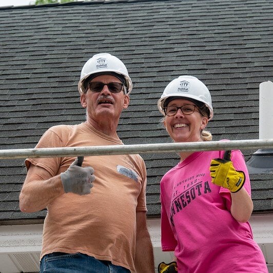 Two volunteers giving thumbs up.