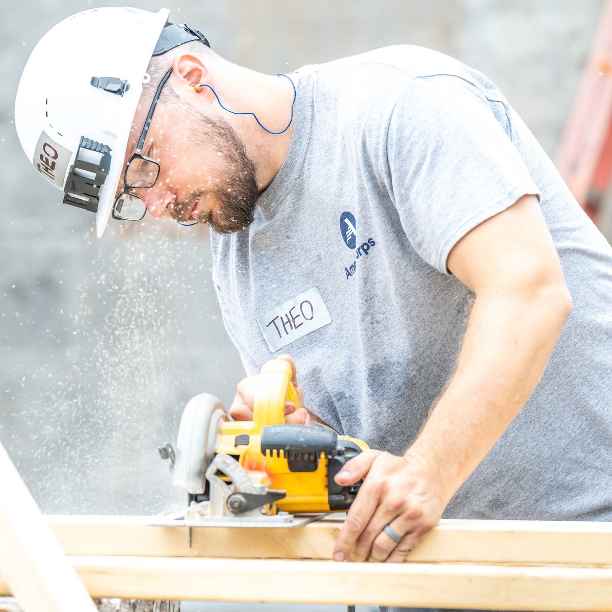 AmeriCorps member using a saw