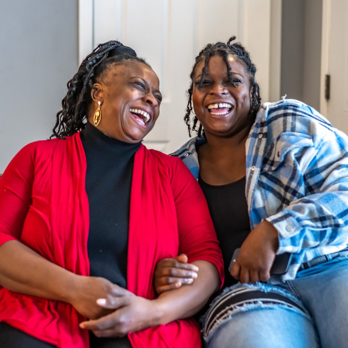 A mother and her adult daughter laughing