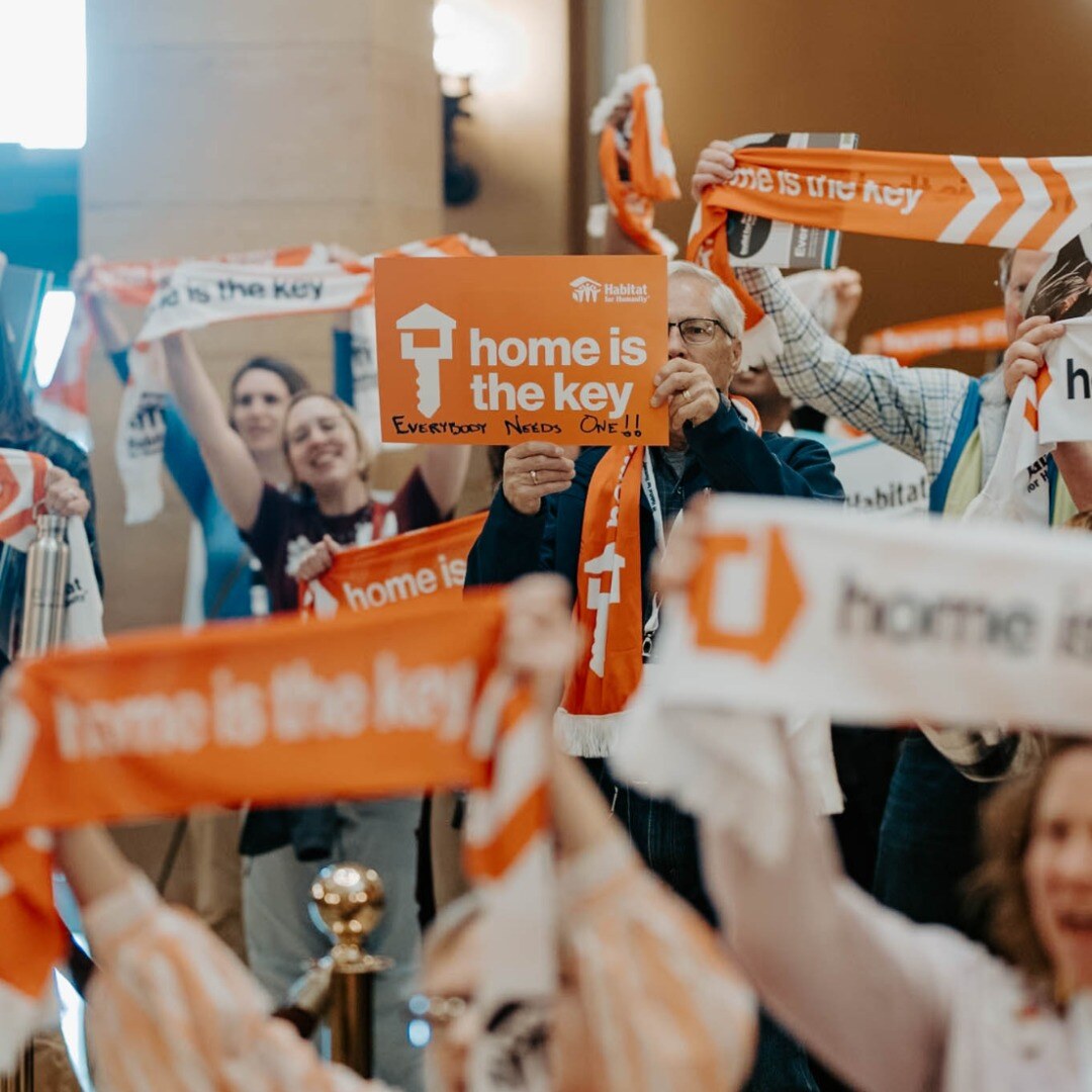 A group of people holding up signs that say home is the key