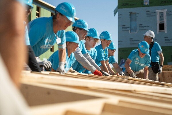 Volunteers raising a wall